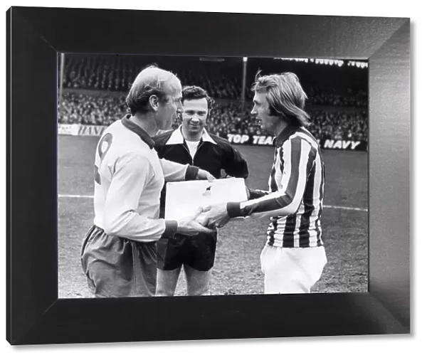 Manchester United footballer BobbY Charlton is presented with a Wedgwood plaque by Stoke