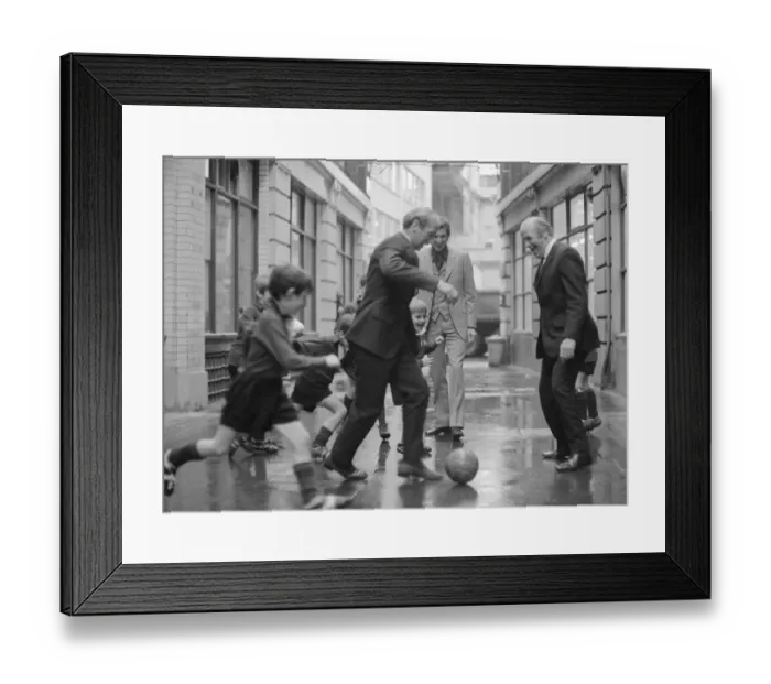 Framed Print : Manchester United and England footballer Bobby Charlton is chased in the street by