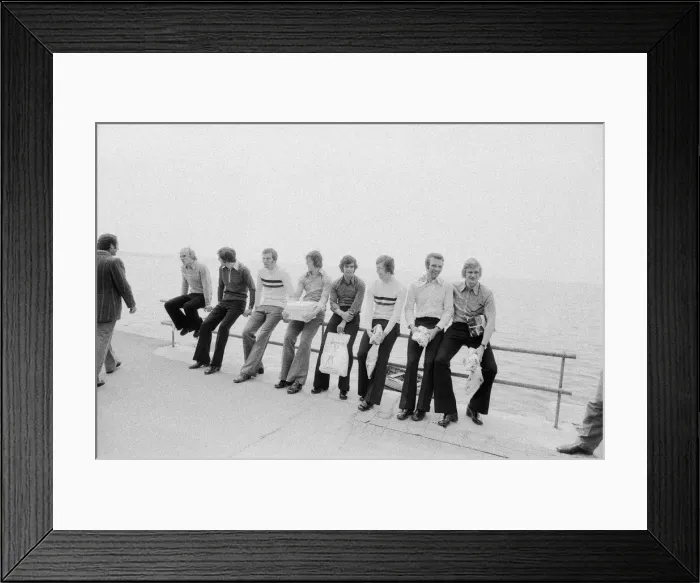 Framed Print : Leeds United players sit on a railing on the promenade as they take a walk around Framed Print : Leeds United players sit on a railing on the promenade as they take a walk around