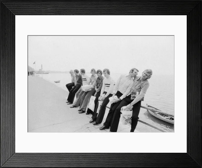 Framed Print : Leeds United players sit on a railing on the promenade as they take a walk around Framed Print : Leeds United players sit on a railing on the promenade as they take a walk around