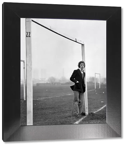 Arsenal footballer Charlie George walking amongst some local football pitches at Hackney