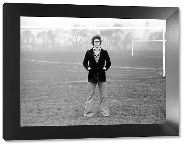 Arsenal footballer Charlie George walking amongst some local football pitches at Hackney