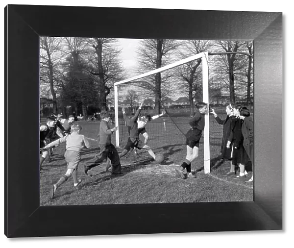 Young goalkeeper is distracted by a group of girls, as a goal is scored, , 20th April 1951