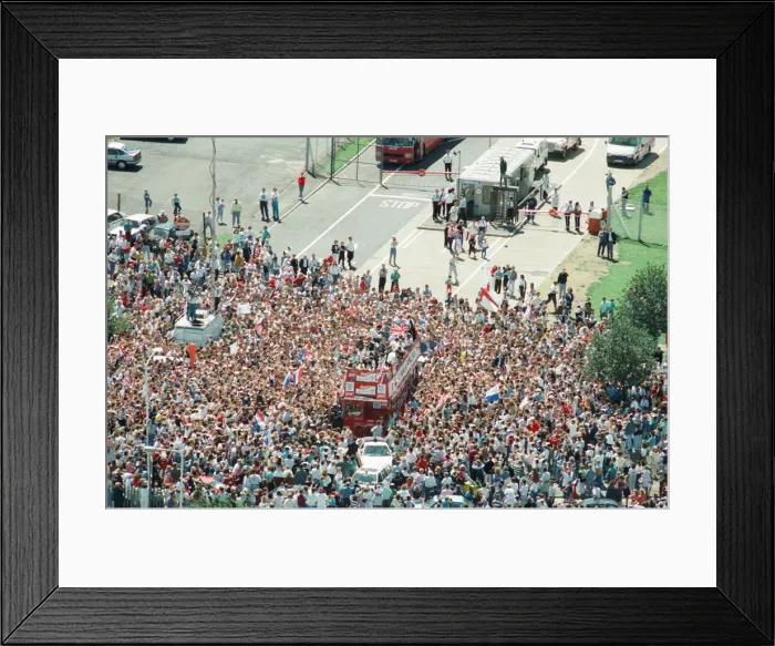 Framed Print : Thousands of England football fans line the streets near Luton airport to welcome their Framed Print : Thousands of England football fans line the streets near Luton airport to welcome their