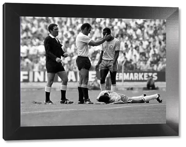 Pele is calmed down by a Uruguain player whilst a felled Jairzinho lies on the ground