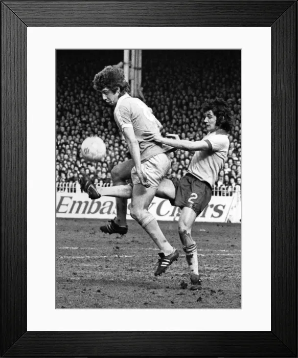 Framed Print : Football - unusual: Brian Kidd of Manchester City gets a kick through his legs by Ipswich