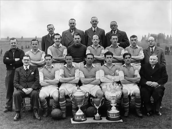 Wigan Athletics football team poses for a group photograph with their three cups