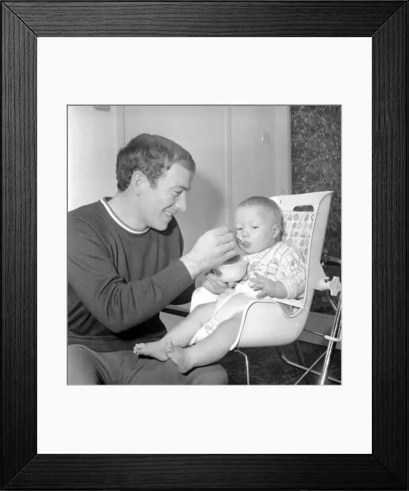 Framed Print : Burnley football player Ralph Coates feeds his new baby girl Lisa. December 1969 Z12543