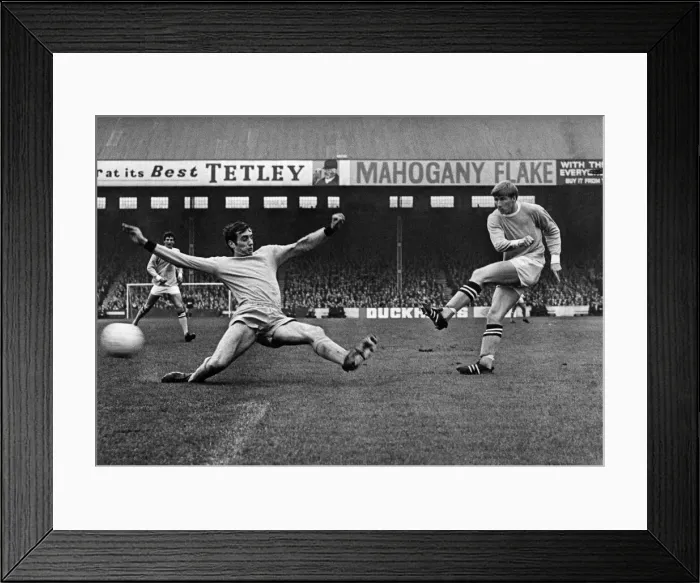 Framed Print : Colin Bell of Manchester City shoots at goal but the Wolves defender blocks the ball
