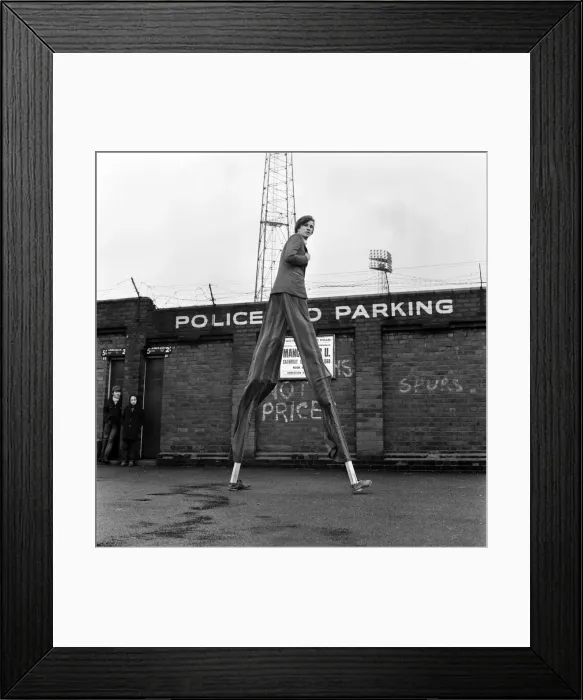Framed Print : Very handy when you are on stilts - football ground walls might as well not be there
