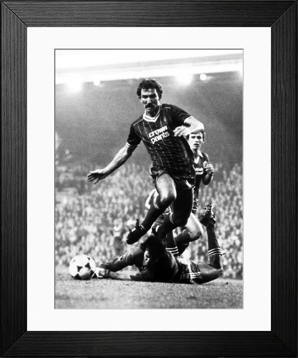 Framed Print : Graeme Souness of Liverpool jumps over Brighton goalkeeper Graham Mosely during the two Framed Print : Graeme Souness of Liverpool jumps over Brighton goalkeeper Graham Mosely during the two