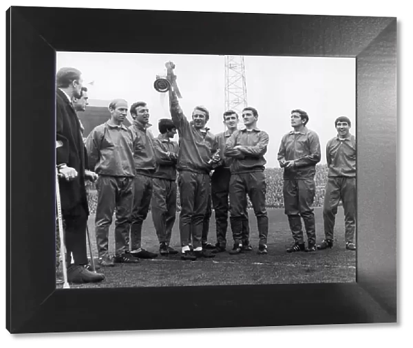 Dennis Law holds the division one championship trophy at Old Trafford with his fellow