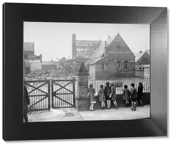 Bomb damage at Saltburn, children looking at a bombed building from a metal fence