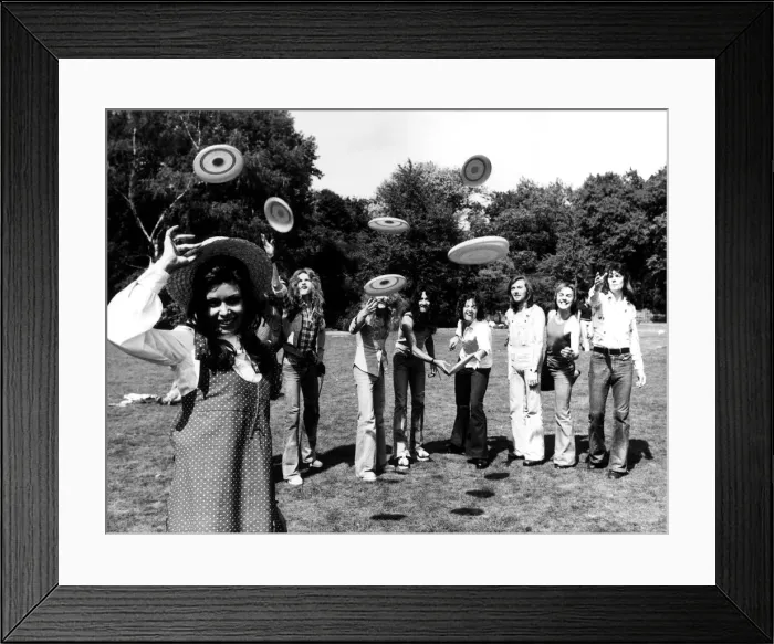 Framed Print : Pop girl Ayshea forms the target for some frisbee throwers. 23rd August 1973 Framed Print : Pop girl Ayshea forms the target for some frisbee throwers. 23rd August 1973