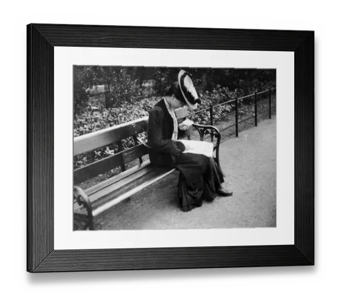 Framed Print : A female bus passengerchecks her used ticket as she sits on abench after descending