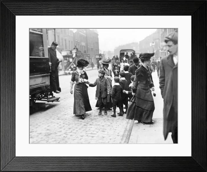Framed Print : A group of children a female tram passenger for her used ticket after she descended
