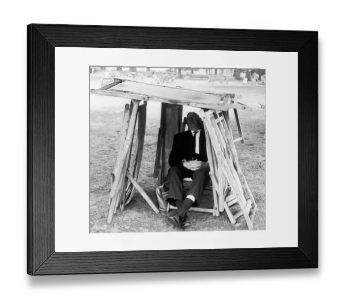 Framed Print : Man using whatever improvised materials he can find including folded up deckchairs to