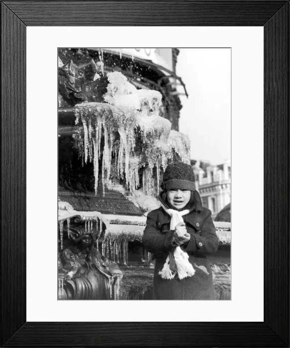 Framed Print : A young girl freezing cold, wrapped up in a coat, hat and scarf Framed Print : A young girl freezing cold, wrapped up in a coat, hat and scarf