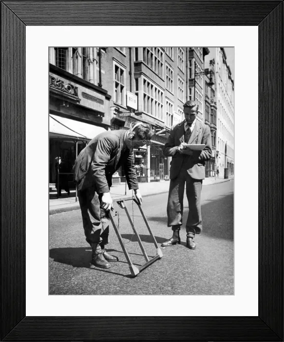 Framed Print : Two men who work for the GPO at work with a mine detector as they try to find a cable of Framed Print : Two men who work for the GPO at work with a mine detector as they try to find a cable of