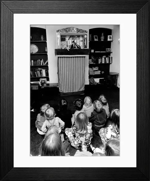 Framed Print : Children sitting on the floor watching the Pinch and Judy puppet show at a party