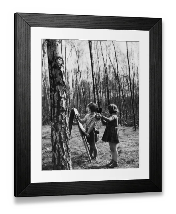 Framed Print : Two girls drawing with crayons and playing with their dolls as they attend their nursery Framed Print : Two girls drawing with crayons and playing with their dolls as they attend their nursery