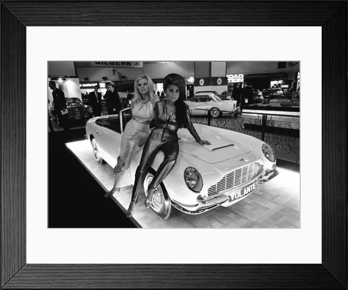 Framed Print : Models pose on the bonnet of a Aston Martin Volante at Motor Show 18th October 1966 Framed Print : Models pose on the bonnet of a Aston Martin Volante at Motor Show 18th October 1966
