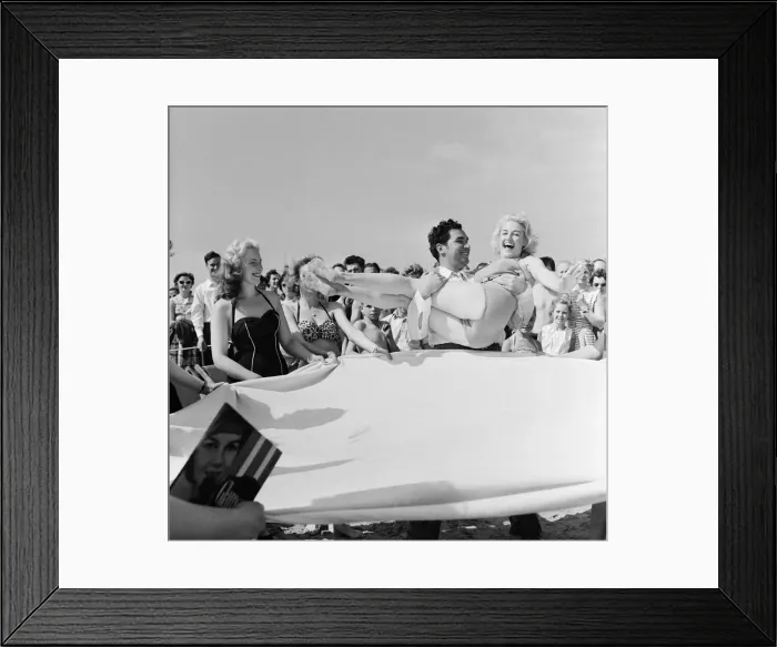 Framed Print : Sunday Pictorial 1957 Beach Party. Angela Manselle being placed on a blanket by Phil Framed Print : Sunday Pictorial 1957 Beach Party. Angela Manselle being placed on a blanket by Phil
