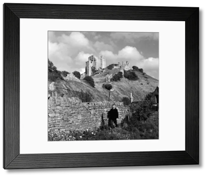 Framed Print : Corfe Castle Dorset rises behind a drystone wall. Corfe Castle Framed Print : Corfe Castle Dorset rises behind a drystone wall. Corfe Castle