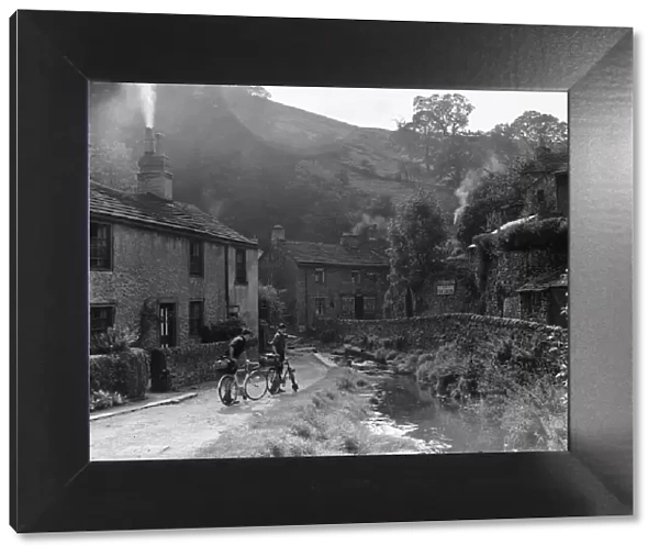 Two boys out on their bicycles near a stream in the Peak District village of Castletown