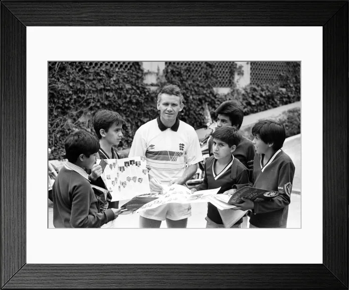 Framed Print : England footballer Peter Reid signs autographs for local children at the team base in