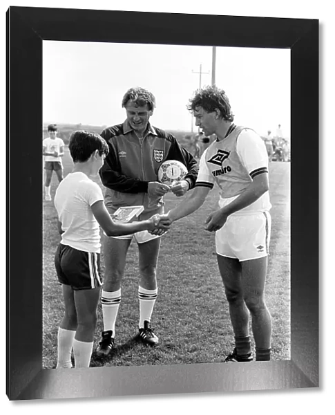 England captain Bryan Robson shakes hands with one of the boys of the local football club