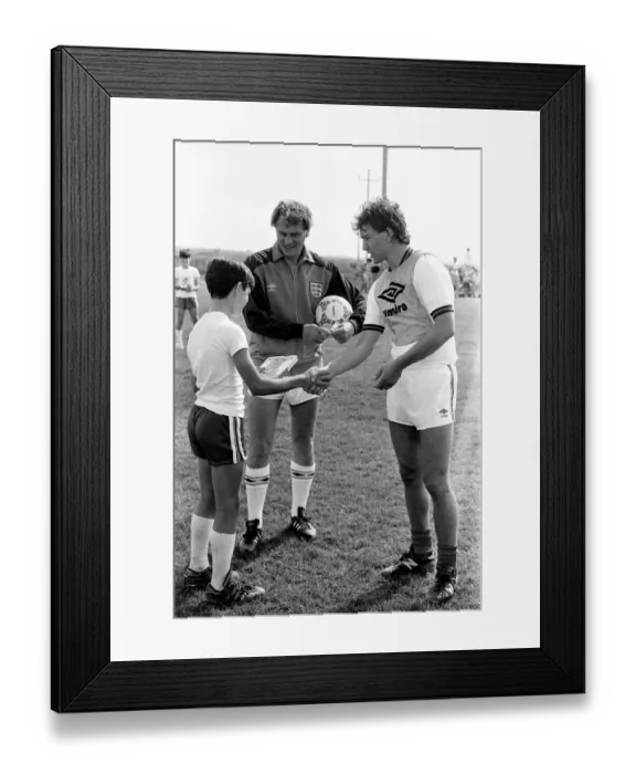 Framed Print : England captain Bryan Robson shakes hands with one of the boys of the local football club