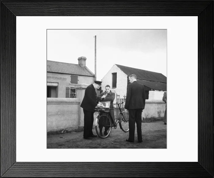 Framed Print : Customs officer checking the documents of a man on a bicycle at the Border Post between