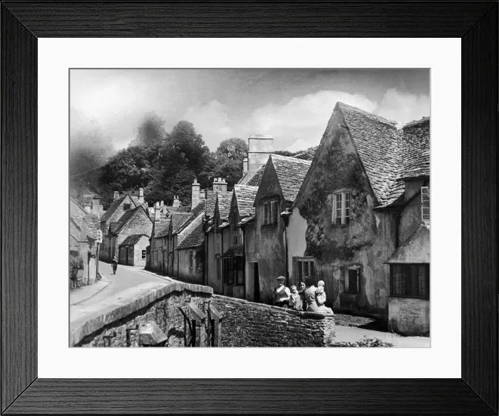 Framed Print : A family takes a rest on a stone wall in a Cotswold village in Gloucestershire