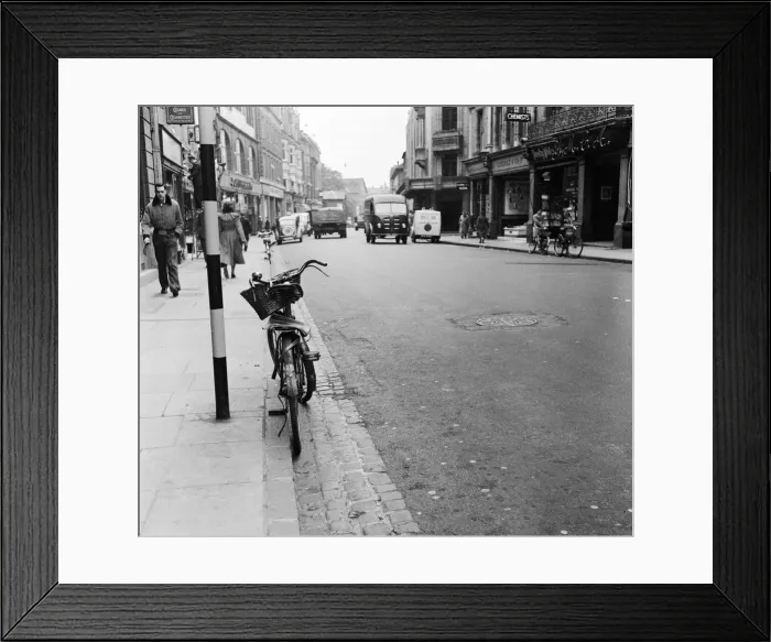 Framed Print : Street scene in Oxford town centre, showing a bicycle parked up against the kerb Framed Print : Street scene in Oxford town centre, showing a bicycle parked up against the kerb