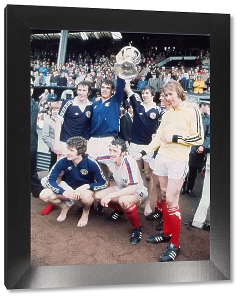Scotland footballer Joe Jordan holds aloft the British International Football trophy with