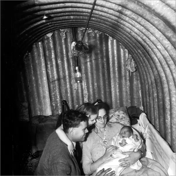 WW2 A family seeks refuge inside an Anderson Air Raid shelter during the blitz