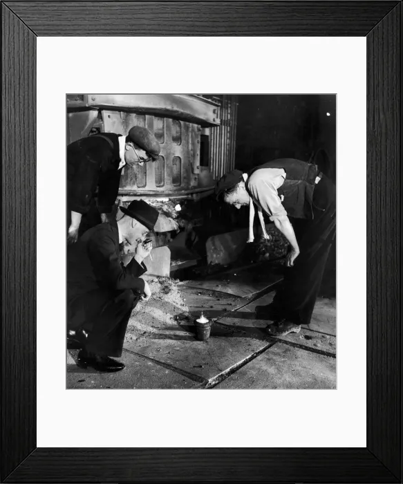 Framed Print : An expert makes a closer examination of a sample of steel taken from a 30 ton Electric