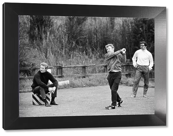 Scotlands Billy Bremner tees off watched by Denis Law during a game of golf at