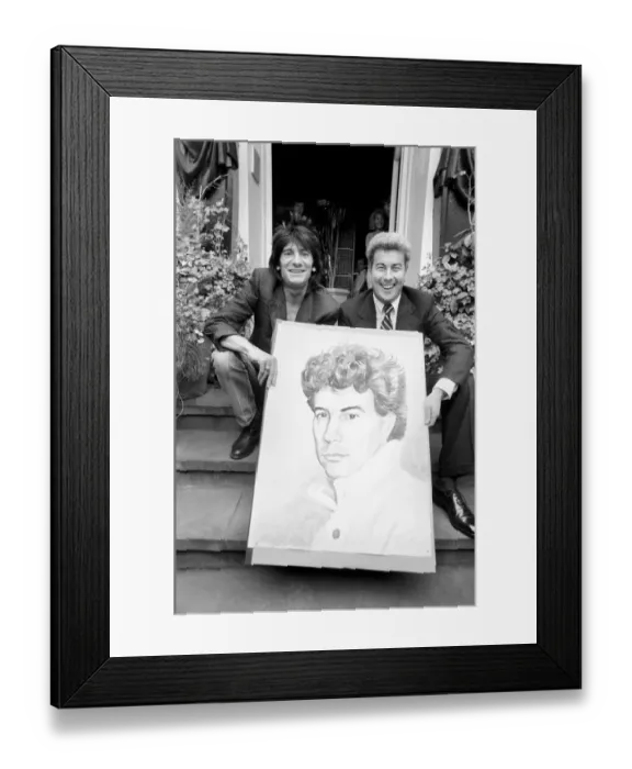 Framed Print : Rolling Stones: Ronnie Wood holds a painting of author Ken Follett who stands next to him