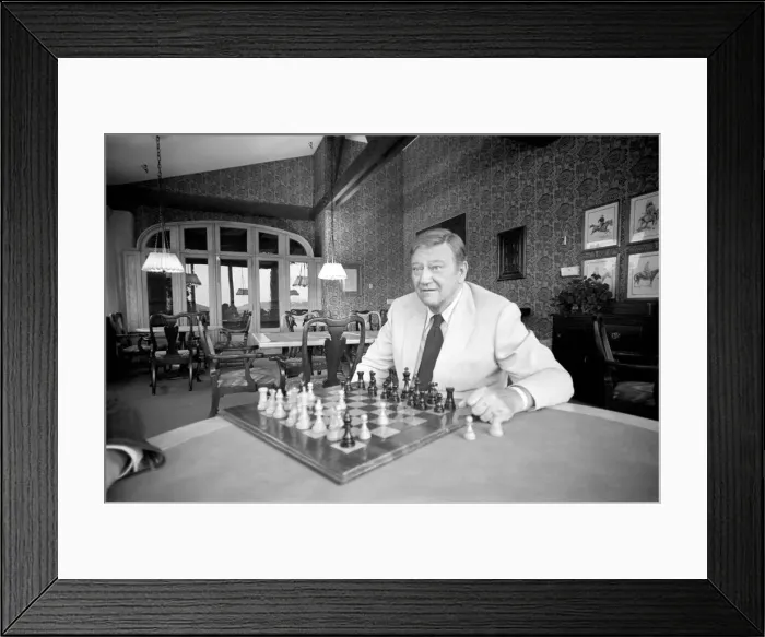 Framed Print : John Wayne who recently starred in Brannigan at home in Texas playing a game of Framed Print : John Wayne who recently starred in Brannigan at home in Texas playing a game of