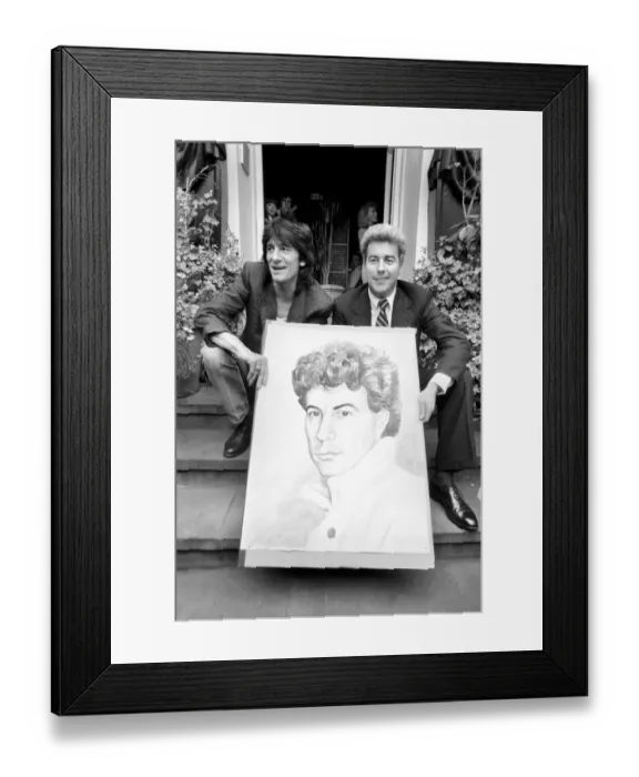 Framed Print : Rolling Stones: Ronnie Wood holds a painting of author Ken Follett who stands next to him