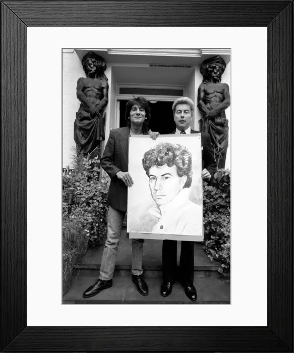 Framed Print : Rolling Stones: Ronnie Wood holds a painting of author Ken Follett who stands next to him