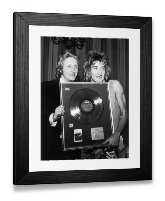 Framed Print : Footballer Denis Law presents singer Rod Stewart of The Faces with a gold disc to mark Framed Print : Footballer Denis Law presents singer Rod Stewart of The Faces with a gold disc to mark