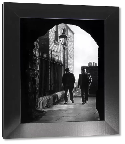 Workmen on their way from the quayside pass through the arch at the head of the Castle