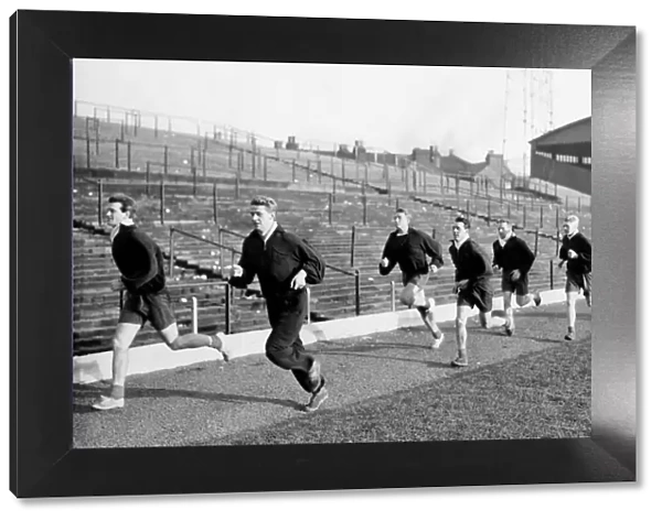 Stoke City players take part in training session, sprinting along the touch line are