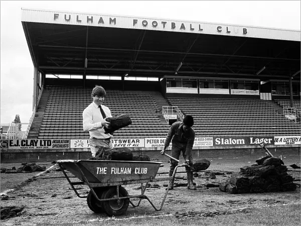 Fulham manager Malcolm Macdonald with a roll of turf at Craven Cottage as the pitch is
