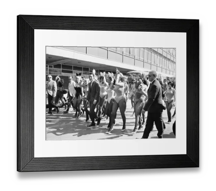 Framed Print : Hugh Hefner Boss of the Playboy Empire arrives with an entourage of Bunny Girls at London