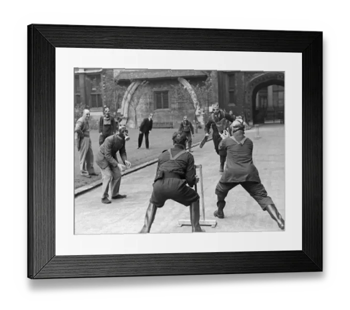 Framed Print : A game of cricket played in an English village by men wearing gas masks May 1941
