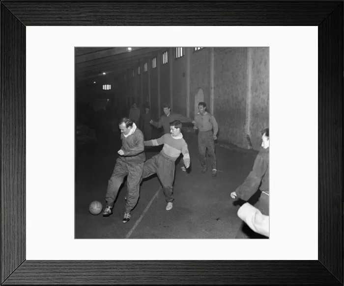 Framed Print : Football players train under one of the stands as snow prevents training at the Brittania
